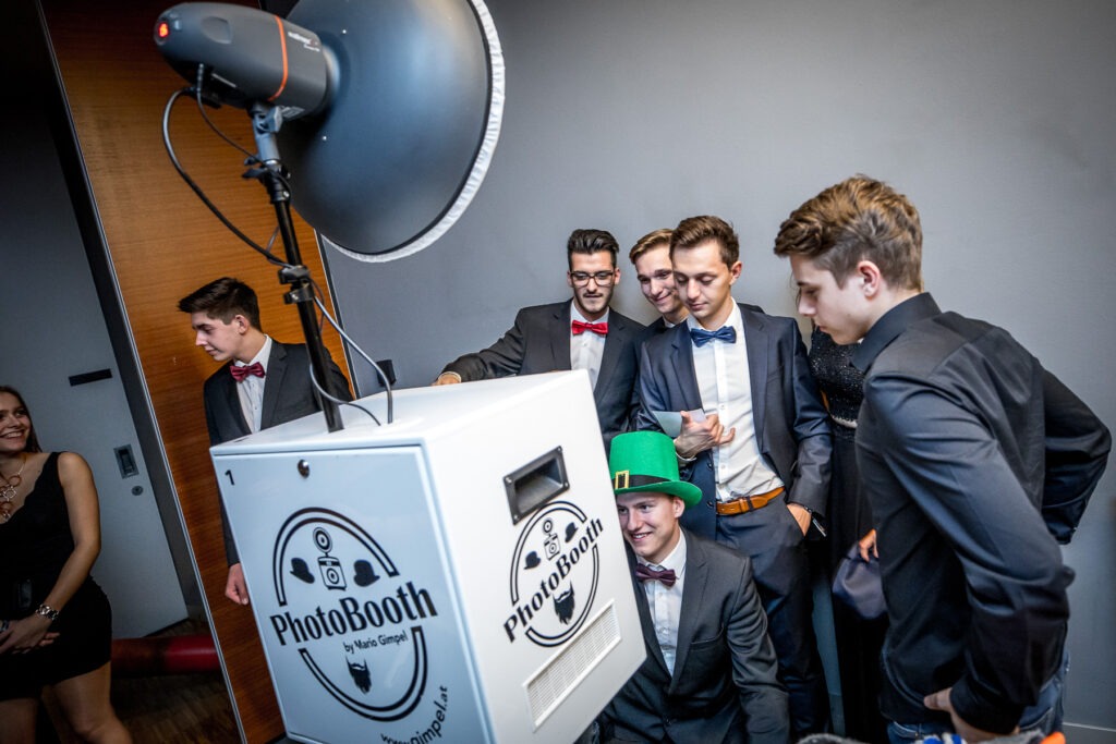 Ballgäste mit Requisiten an der Fotobox am Maturaball