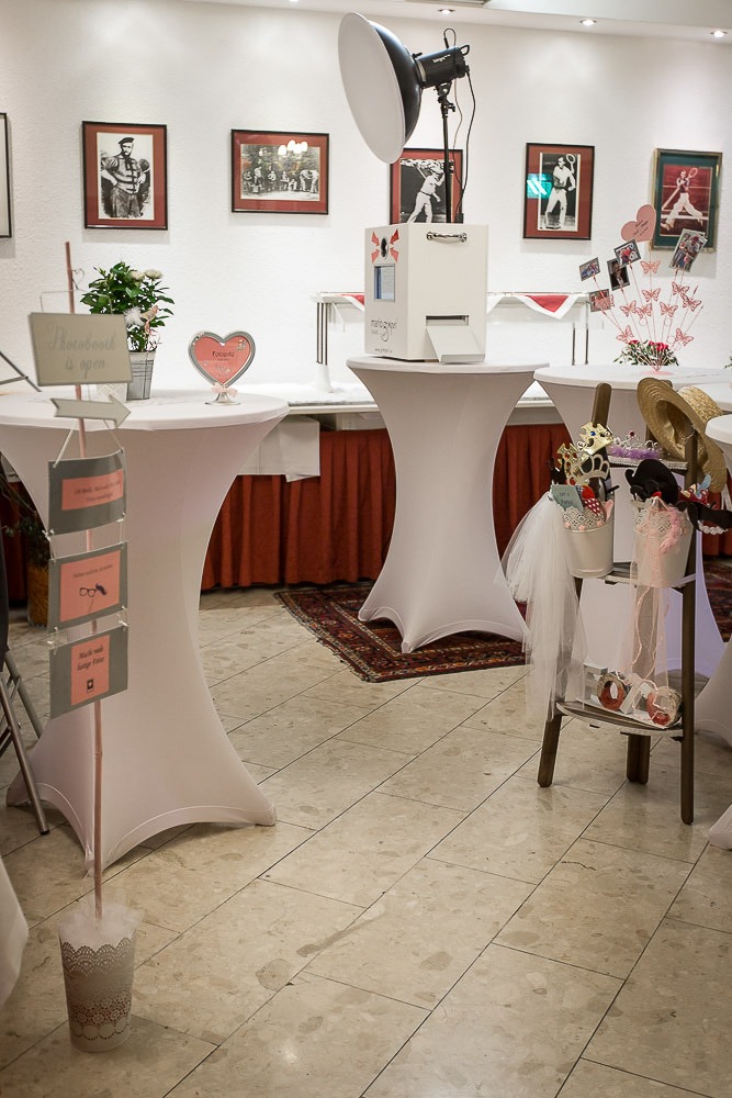 Aufgebaute Fotobox mit Blitzanlage und Requisitentisch bei einer Feier